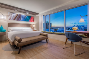 hotel room with large window and skyline view