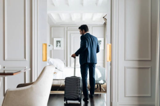 business traveler entering guest room with luggage