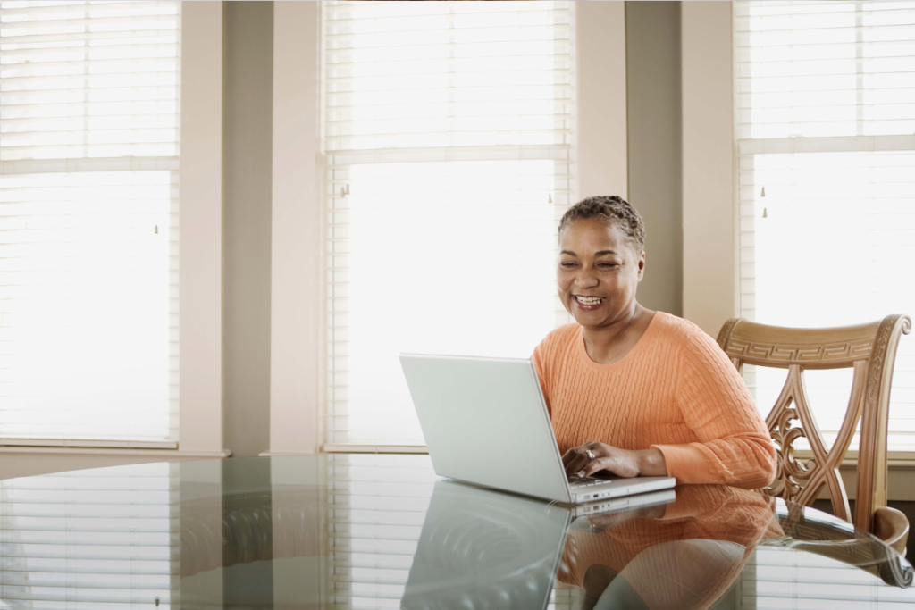 woman sitting at table using laptop