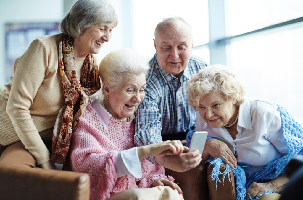 several senior living residents looking at content on a mobile phone