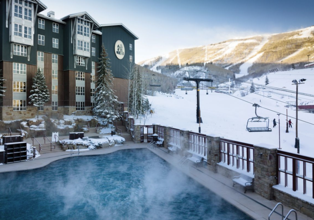 exterior of Marriott MountainSide villas showing heated pool in foreground and ski lift in background