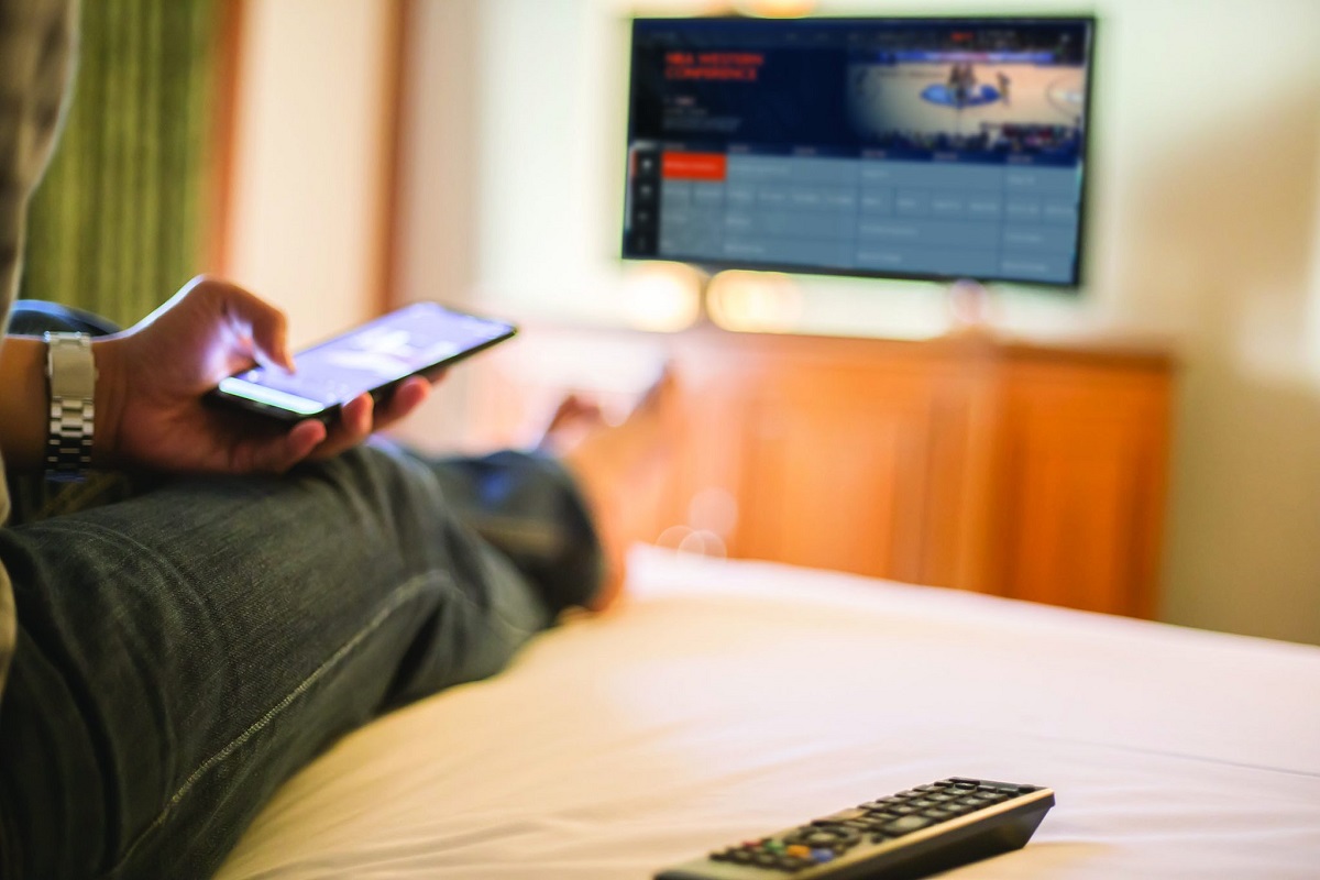 guest using phone and TV in hotel room