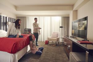 family in hotel room using TV