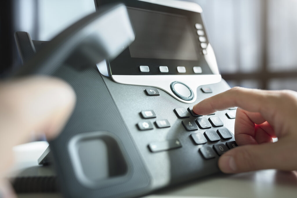 voice services with person dialing a call on a VoIP phone