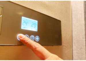 person touching smart thermostat