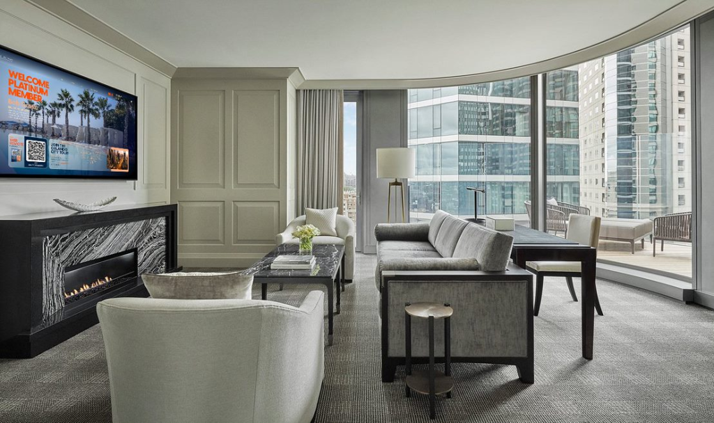 living room area of hotel suite, with The HUB on TV