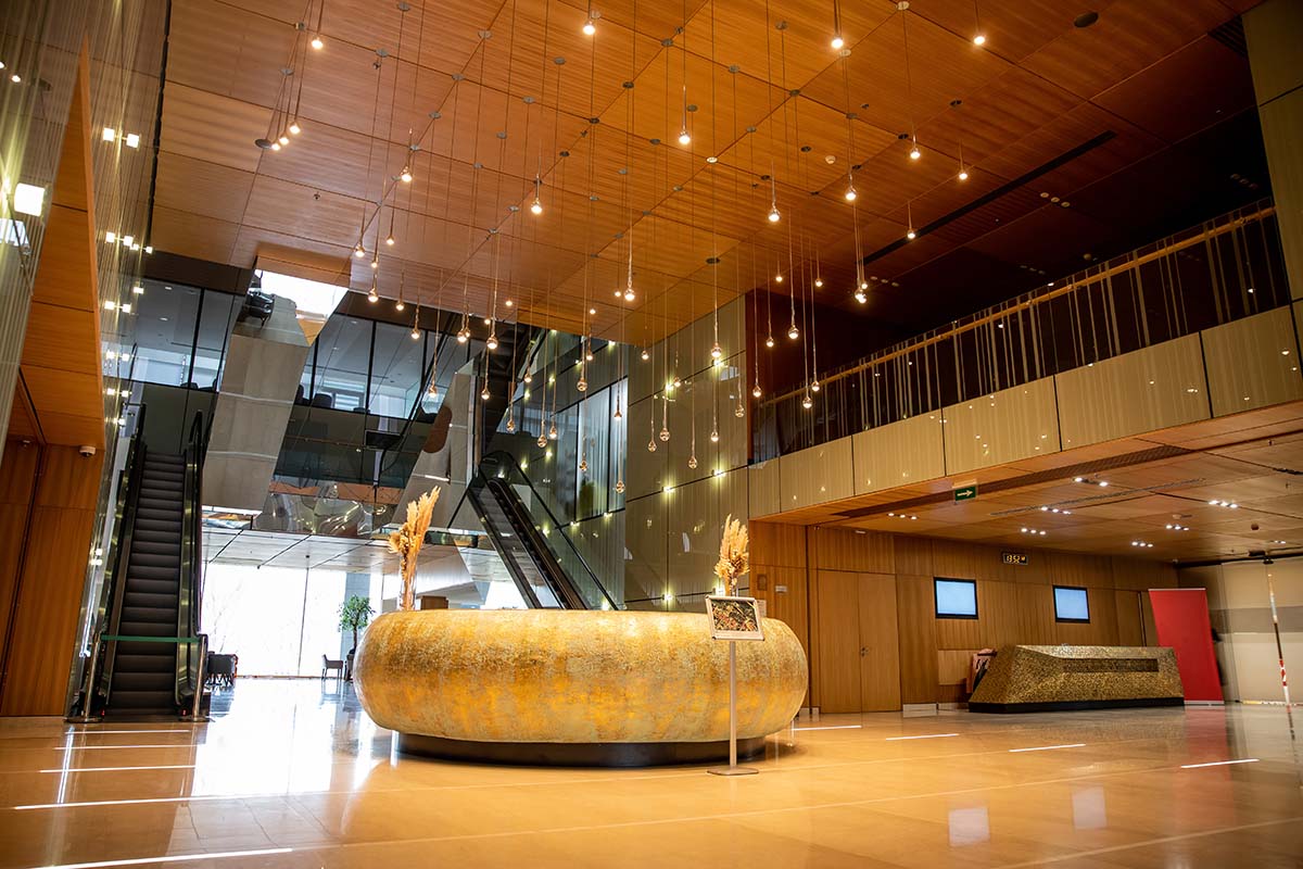 modern hotel interior with round reception desk and sophisticated lobby design, escalators, moving staircase, luxurious ambience, spacious and comfort, classy and chic