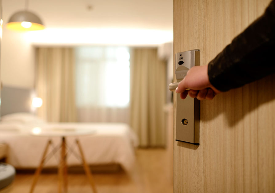 person opening the door to a hotel room