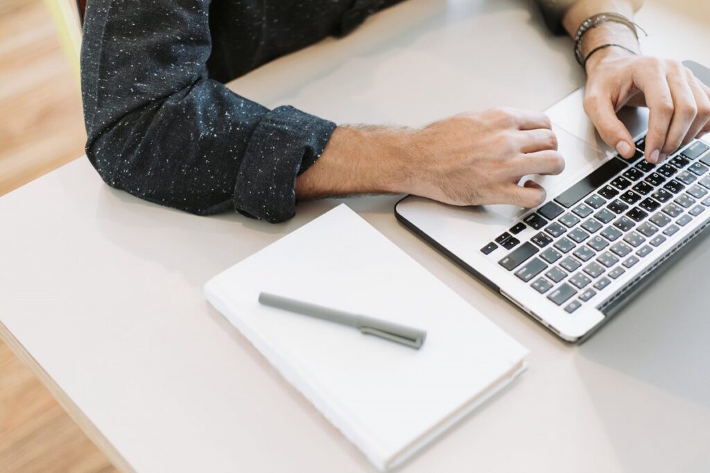 remote traveler working at desk with laptop and notepad