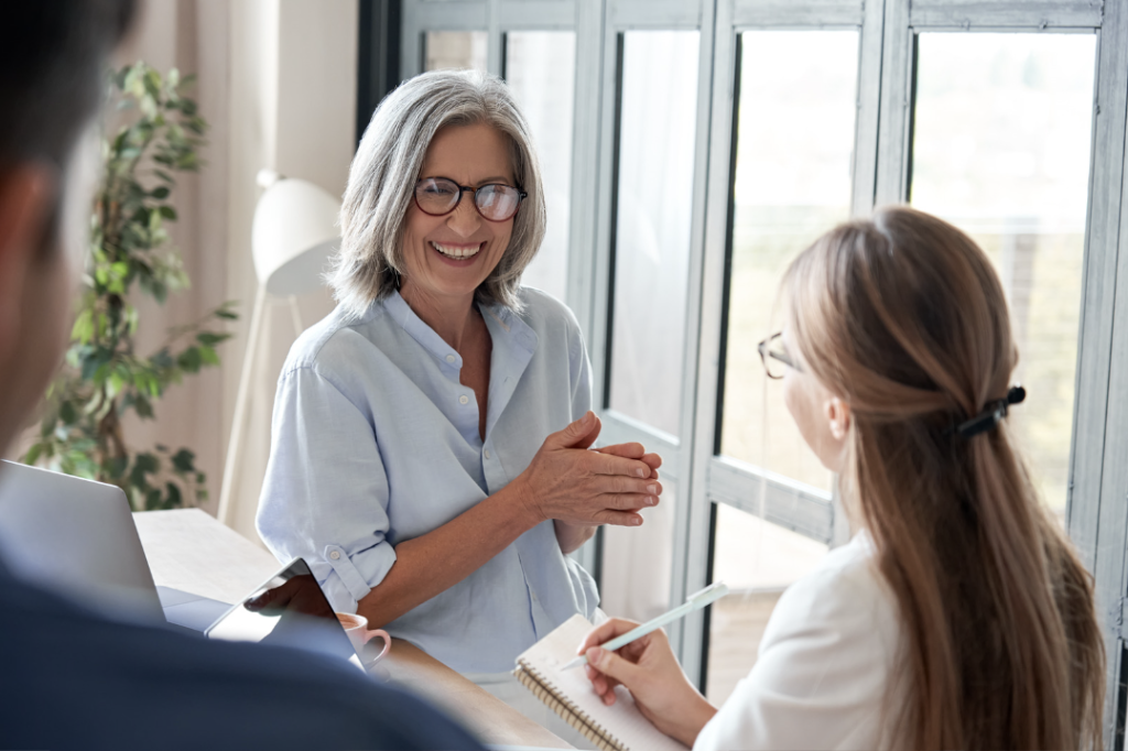 senior living resident smiling at staff member writing in notebook