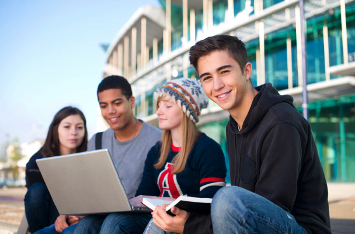 students sharing laptop