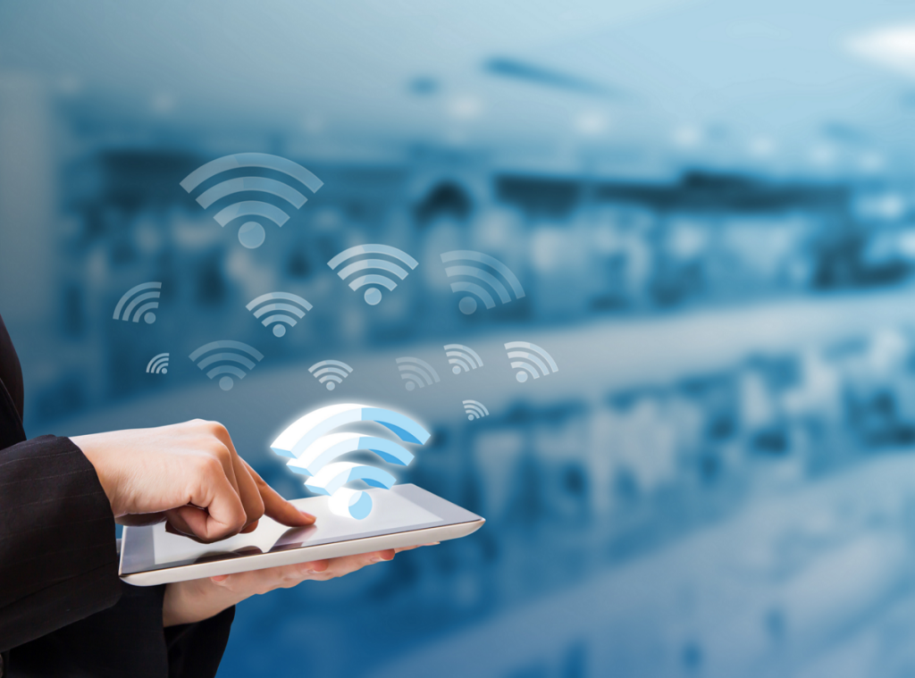 person tapping on tablet with wifi symbols in the air