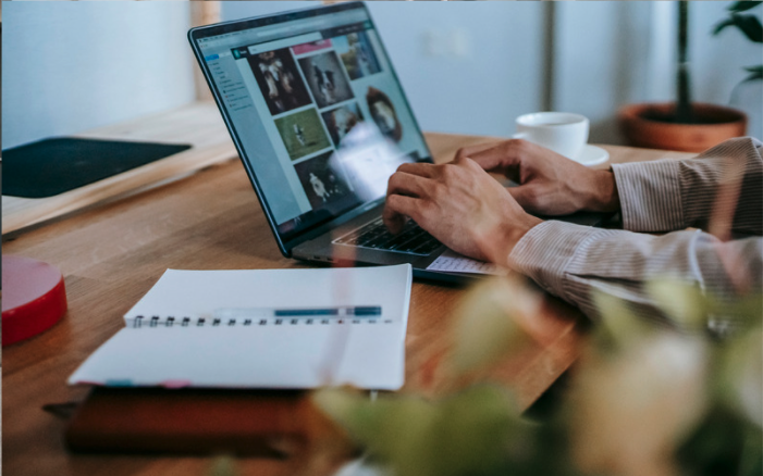 person working remotely with laptop and notebook