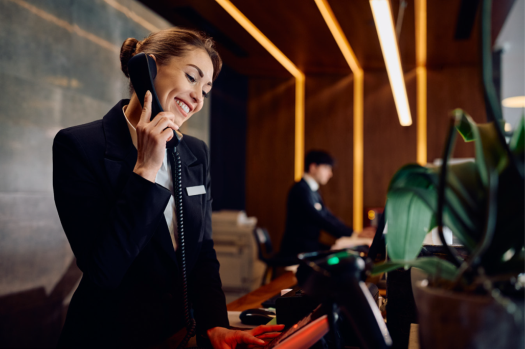 Hotel front desk staff using a phone for guest support